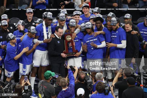 The Duke Blue Devils pose for photos holding the regional champion trophy after defeating the Arkansas Razorbacks 78-69 in the NCAA Men's Basketball...