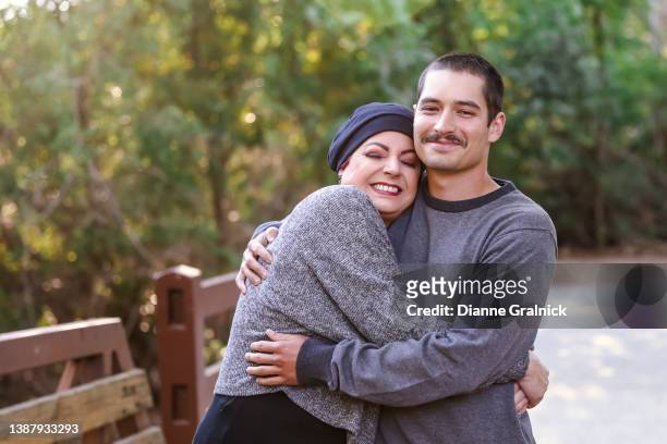 mom with cancer hugging older son - cancer patient with family stock pictures, royalty-free photos & images