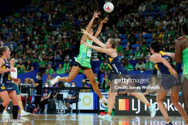 Emma Cosh of the fever jump up to pass the ball over Maddison Hinchliffe of the lightning during the round one Super Netball match between West Coast...