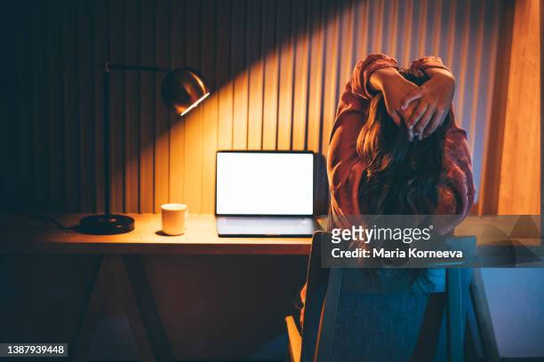 freelancer woman works at laptop in evening. - frustración fotografías e imágenes de stock