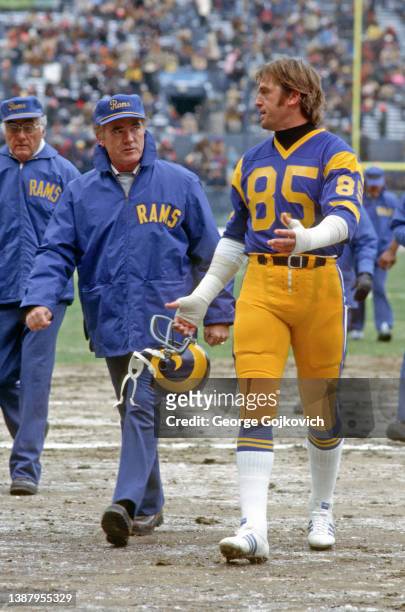 Defensive lineman Jack Youngblood of the Los Angeles Rams talks to head coach Chuck Knox as they walk off the field after a game against the...