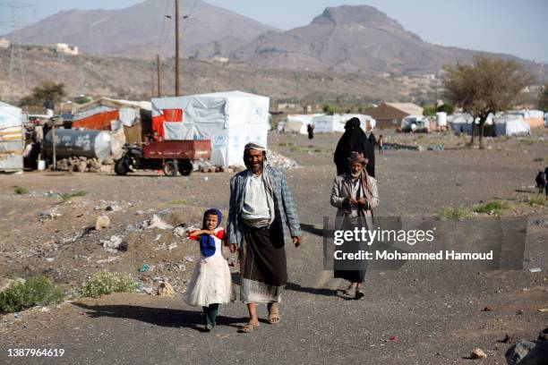 Yemeni internally displaced person and his children, who fled homes escaping conflict, are seen at a displaced persons camp on the outskirts of...