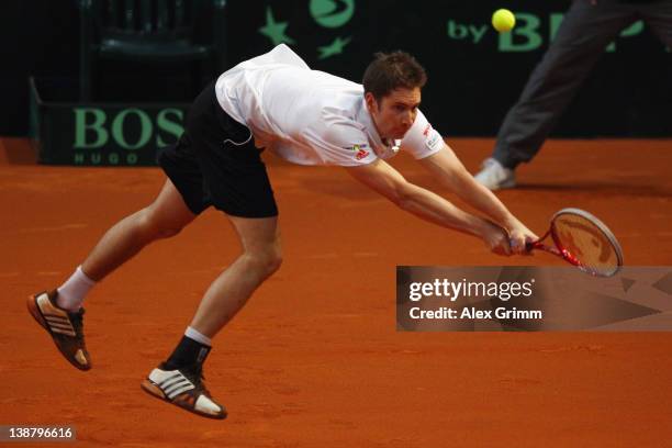 Florian Mayer of Germany returns the ball to Juan Ignacio Chela of Argentina on day 3 of the Davis Cup World Group first round match between Germany...