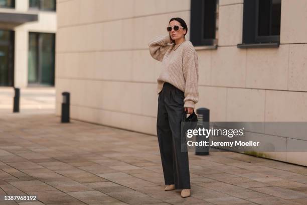 Elise Seitz is seen wearing Bottega Veneta black mini jodie bag, Paul Hewitt beige shades, Viky Rader grey pants, Soho Studios beige knit sweater and...