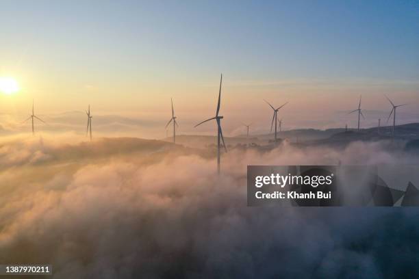 the beautiful turbines of wind power in the sky at dawn - windmill stock-fotos und bilder