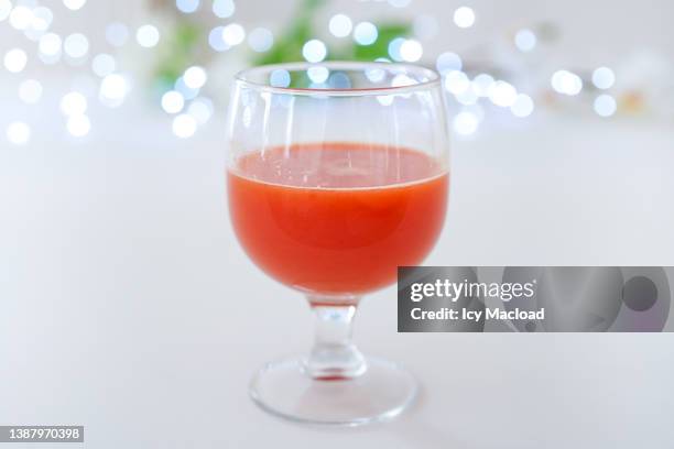 orange juice, grapefruit juice, tomato juice, citrus juice in a stemmed glass with a blurred background - tomatensap stockfoto's en -beelden