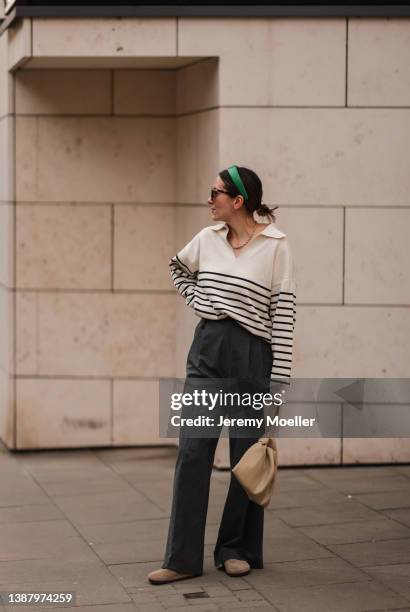 Elise Seitz is seen wearing Cotton Candy stripe beige and navy blue sweater, Nanushka beige leather bag, Viky Rader grey pants, Rotate green hair...