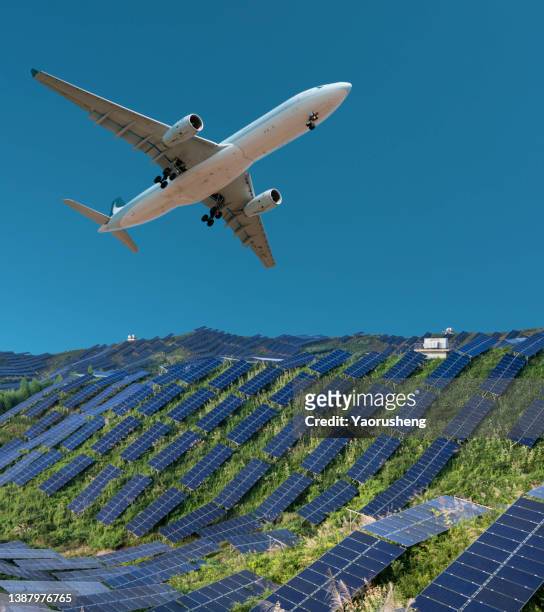 airplane flying over the solar panel plant in a sunny day - aircraft landing stock pictures, royalty-free photos & images