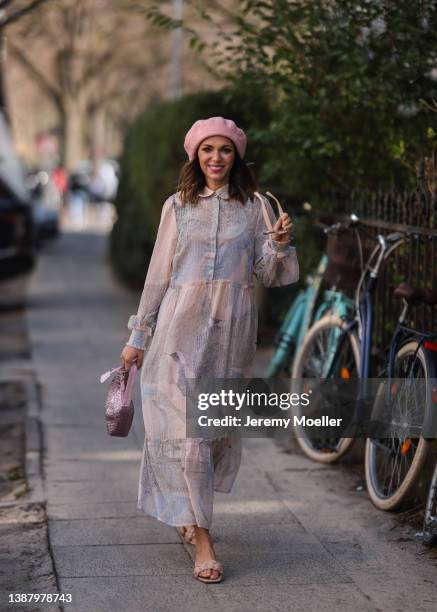 Anna Wolfers wearing a pink Prada Mini Hobo bag, a pink hat, beige and brown shades, a pink and grey maxi dress with pattern and beige sandals via...