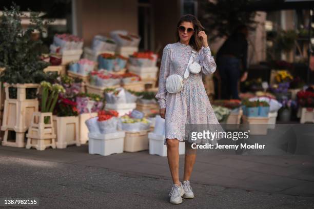 Anna Wolfers wearing brown shades, a pink floral midi dress and a white leather bag via goldigshop.de and white selected femme sneaker on March 25,...