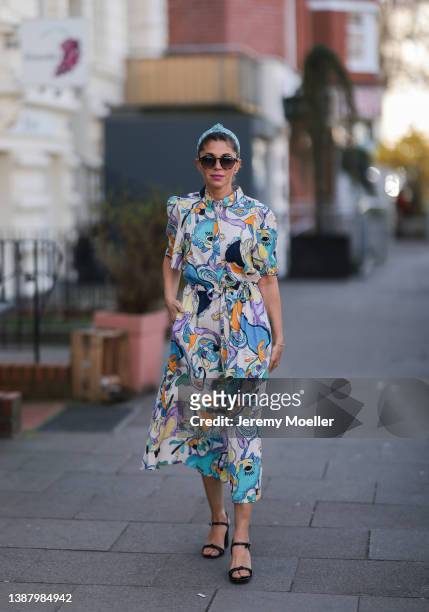 Anna Wolfers wearing a blue hair band, brown shades, a colorful and floral maxi dress and black heels via goldigshop.de on March 25, 2022 in Hamburg,...