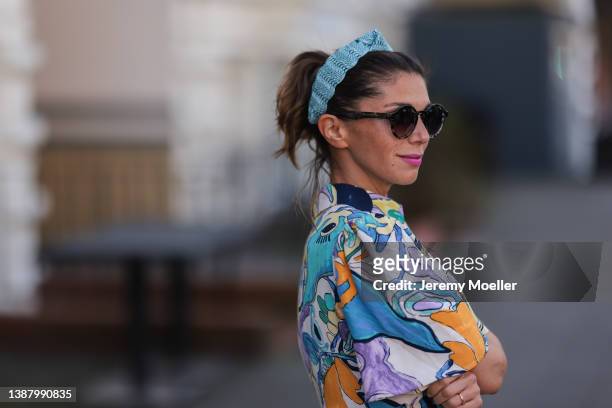 Anna Wolfers wearing a blue hair band, brown shades, a colorful and floral maxi dress via goldigshop.de on March 25, 2022 in Hamburg, Germany.