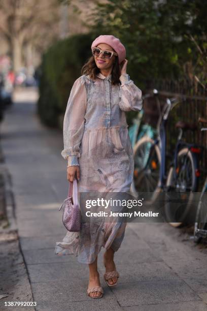 Anna Wolfers wearing a pink Prada Mini Hobo bag, a pink hat, beige and brown shades, a pink and grey maxi dress with pattern and beige sandals via...