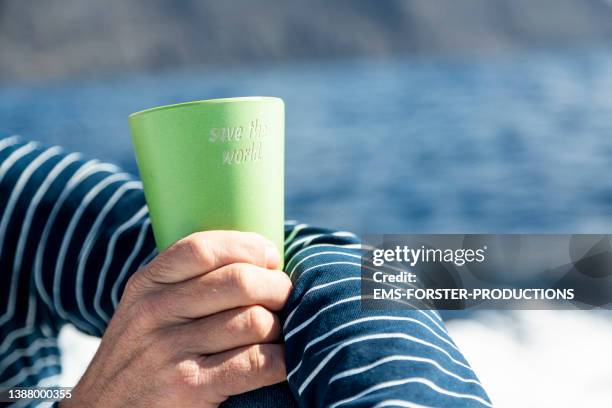 close-up of hands of a man holding recyclable takeaway coffee cup - reusable cup stock pictures, royalty-free photos & images