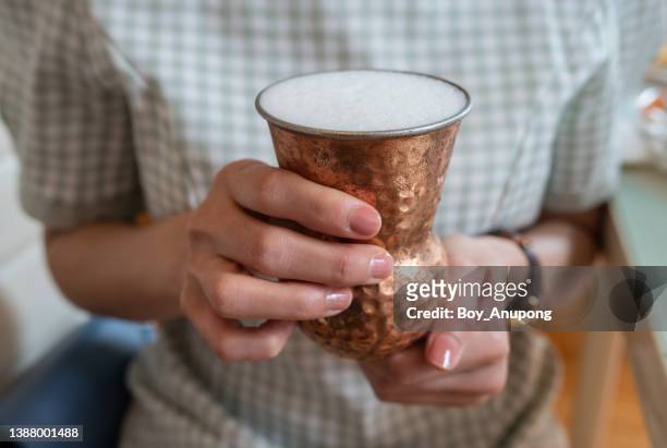 cropped shot of woman holding a bronze cup of indian yogurt before drinking. - lactobacillus stock pictures, royalty-free photos & images