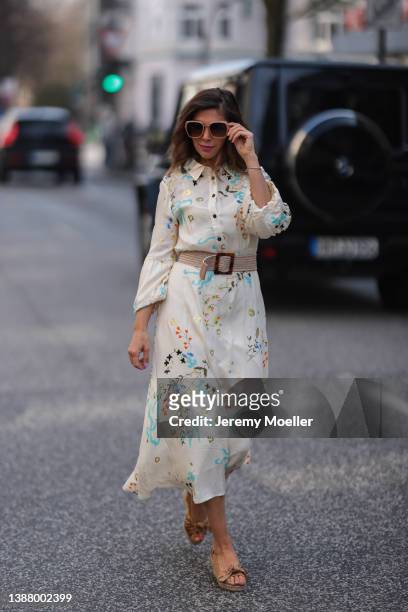 Anna Wolfers wearing beige shades, a beige maxi dress with floral pattern, a beige belt and beige heels via goldigshop.de on March 25, 2022 in...
