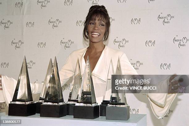 File picture taken on February 8, 1994 in Los Angeles shows US singer Whitney Houston posing with the seven awards she won at the 21st annual...
