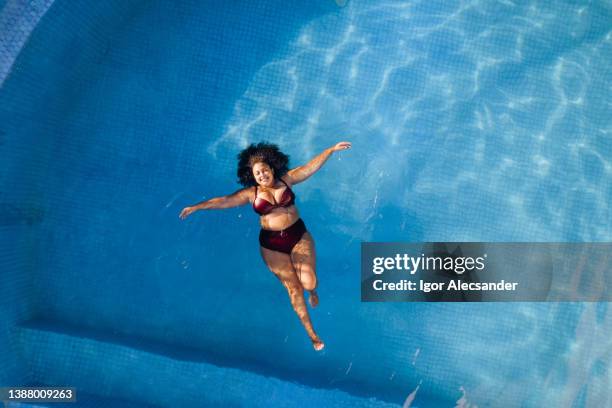 top view of woman relaxing in swimming poll - body positive stockfoto's en -beelden