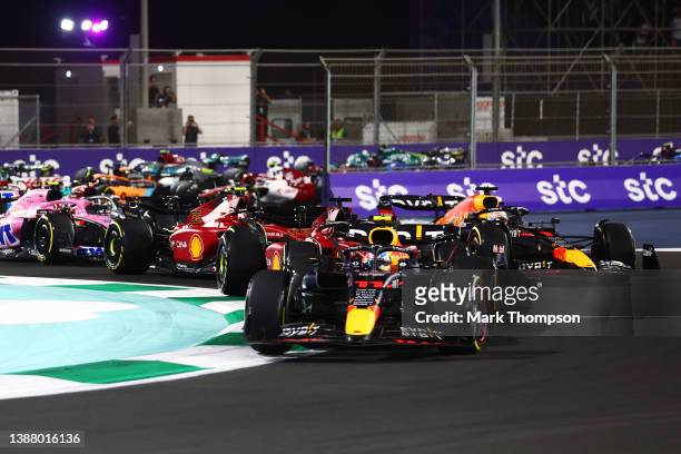 Sergio Perez of Mexico driving the Oracle Red Bull Racing RB18 leads Charles Leclerc of Monaco driving the Ferrari F1-75 and the rest of the field at...
