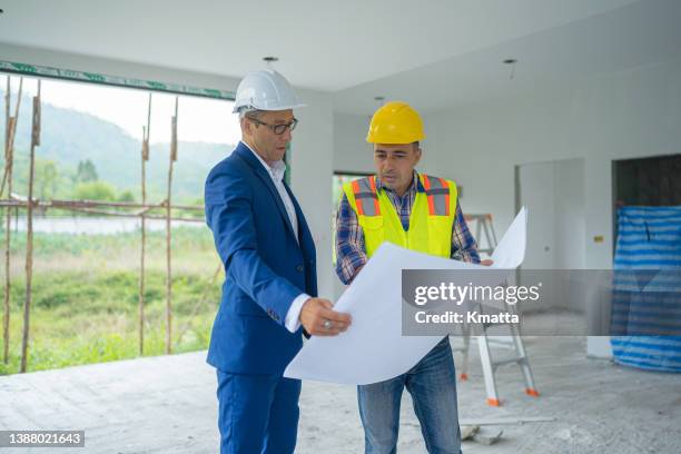 real estate agent manager and architect reviewing blueprint at home construction site. - industrial estate ストックフォトと画像