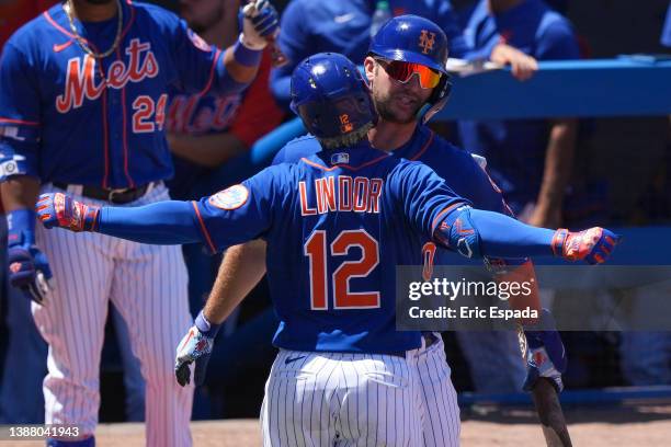 Francisco Lindor of the New York Mets is congratulated by Pete Alonso after hitting a home run during the third inning of the Spring Training game...