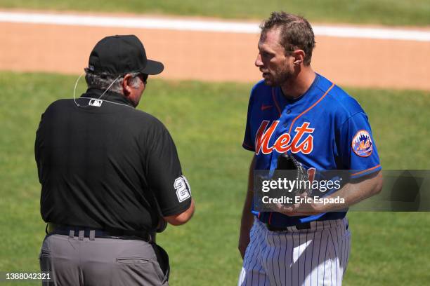 Umpire Hunter Wendelstedt checks the glove of Max Scherzer of the New York Mets after the fourth inning of the Spring Training game against the St....