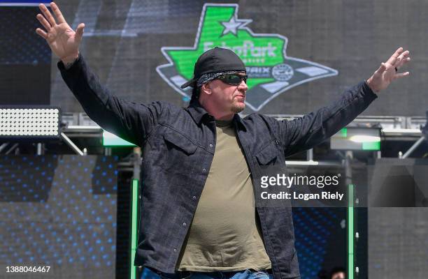 Professional wrestler The Undertaker walks onstage during pre-race ceremonies prior to the NASCAR Cup Series Echopark Automotive Grand Prix at...