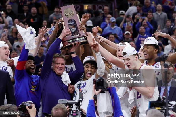 The Kansas Jayhawks celebrate with the Midwest Regional Championship trophy after the 76-50 win over the Miami Hurricanes in the Elite Eight round...