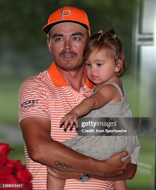 Golfer Rickie Fowler holding his daughter Maya Fowler on July 2 after the final round after winning the Rocket Mortgage Classic at the Detroit Golf...