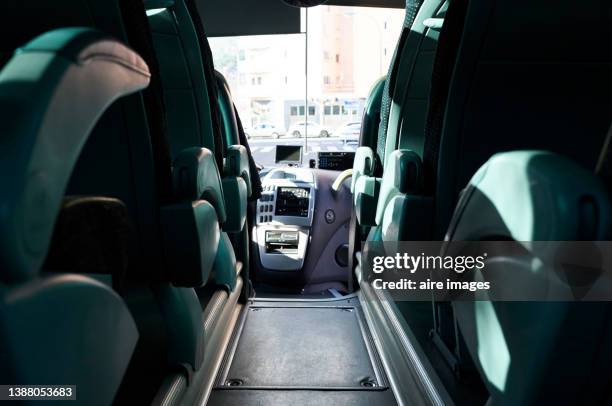 bus seats with textile upholstery in rows, leather armrests and seat belt holders, modern and comfortable tourist transportation interior. - coach bus stock pictures, royalty-free photos & images