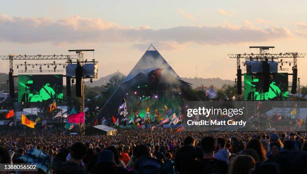 Crowds gather in front of the main Pyramid Stage as the sun begins to set during the 2016 Glastonbury Festival held at Worthy Farm, in Pilton near...