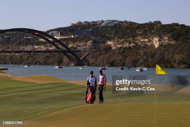 Scottie Scheffler of the United States and his caddie Ted Scott look on on the 14th hole in his finals match against Kevin Kisner of the United...