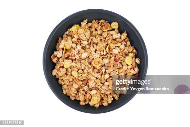 granola in a black plate, isolated on white background - cereal bowl stockfoto's en -beelden