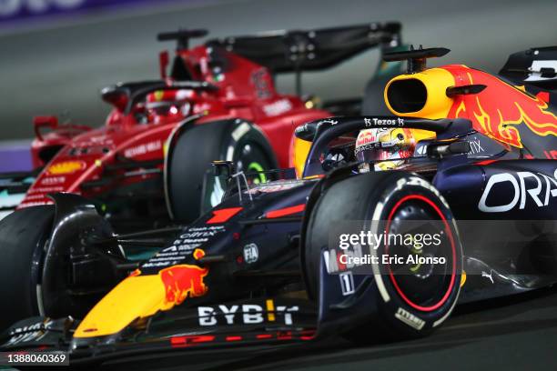 Max Verstappen of the Netherlands driving the Oracle Red Bull Racing RB18 Honda overtakes Charles Leclerc of Monaco driving the Ferrari F1-75 during...