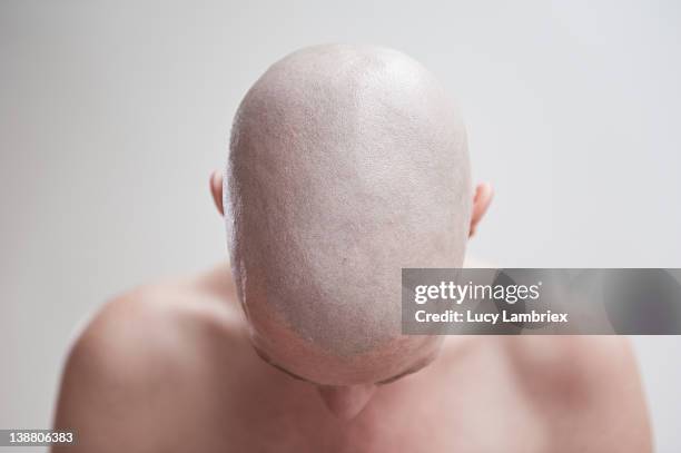 bald woman bowing her head - shaved head fotografías e imágenes de stock