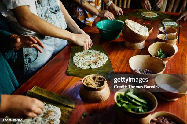 medium close up shot of woman making mayan tamale during cooking class while on vacation - tradición fotografías e imágenes de stock