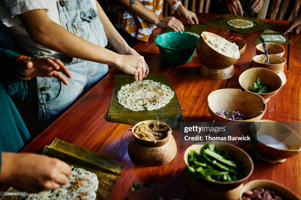 Medium close up shot of woman making Mayan tamale during cooking class while on vacation