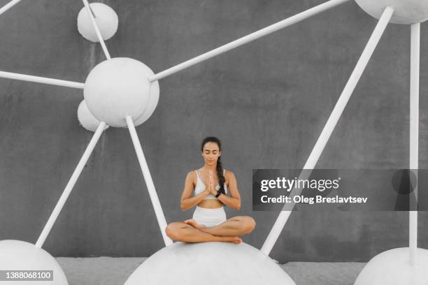 woman praying and meditating on morning yoga. inward harmony, mental health and body care. calm and tranquility - brain workout stock-fotos und bilder