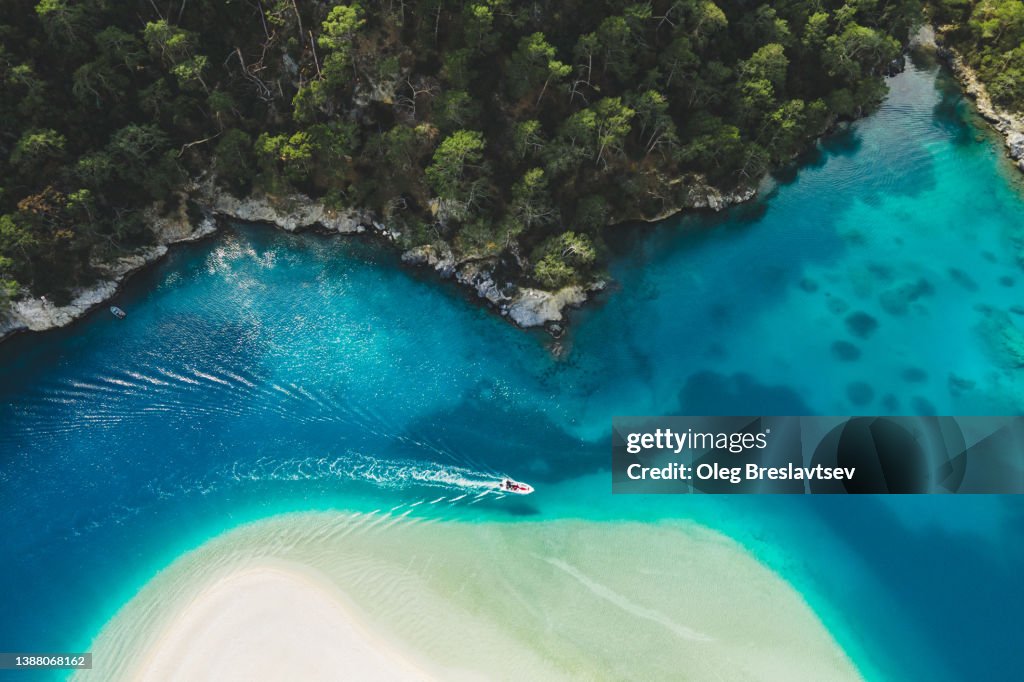 Aerial drone view of Oludeniz Blue Lagoon with turquoise sea, paradise white sand beach and tourist boat
