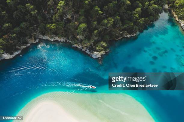 aerial drone view of oludeniz blue lagoon with turquoise sea, paradise white sand beach and tourist boat - tropical climate stock-fotos und bilder