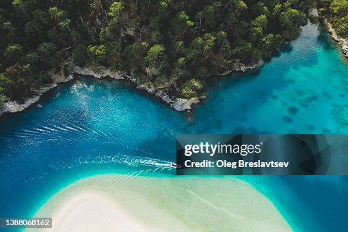 Aerial drone view of Oludeniz Blue Lagoon with turquoise sea, paradise white sand beach and tourist boat Aerial drone view of Oludeniz Blue Lagoon with turquoise sea, paradise white sand beach and tourist boat
