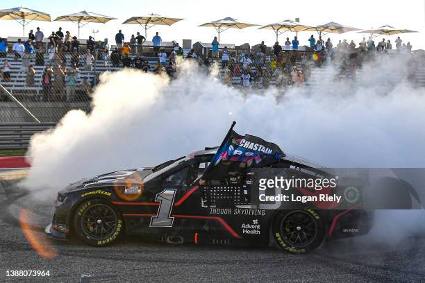 Ross Chastain, driver of the ONX Homes/iFly Chevrolet, celebrates with a burnout after winning the NASCAR Cup Series Echopark Automotive Grand Prix...