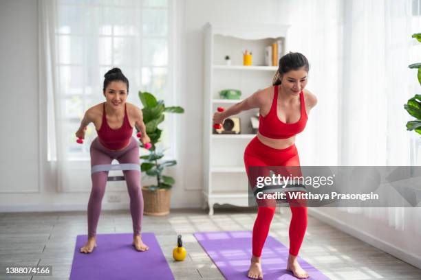 asian chinese female friends practicing yoga in domestic living room together - lifehack stockfoto's en -beelden