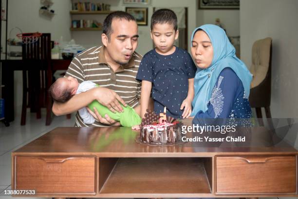 birthday boy blowing candle - parents children blow candles asians foto e immagini stock