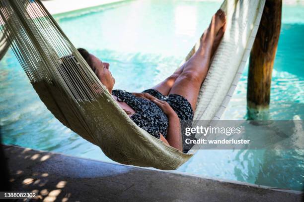 swaying in a poolside hammock - swaying stock pictures, royalty-free photos & images