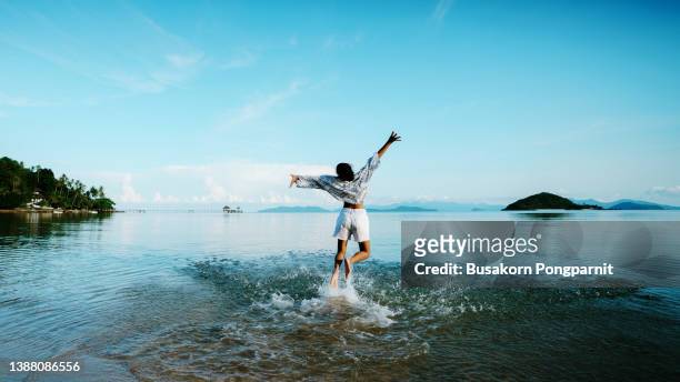 a young girl running on the beach - girls in wet dresses stock-fotos und bilder