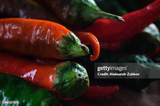 red and green ripe and unripe hot chili peppers in on a wooden background or kitchen table. growing organic farm products. cooking, spices for gourmets. - hot pepper bildbanksfoton och bilder