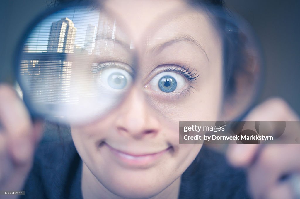 Woman holding two magnifying glasses