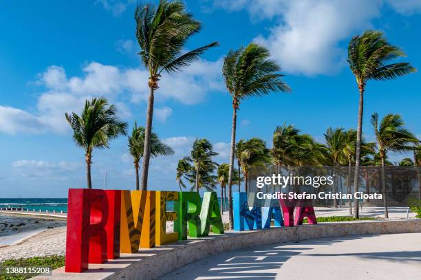 name riviera maya in colorful letters on beach  by tropical caribbean sea shoreline mexico - mayan riviera stock pictures, royalty-free photos & images