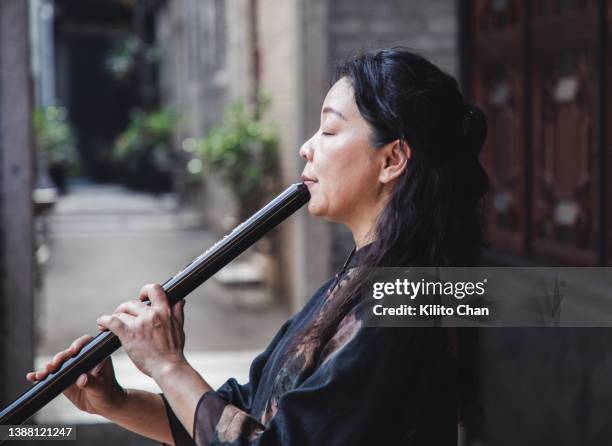 senior asian woman playing shakuhachi flute - 木管楽器 ストックフォトと画像